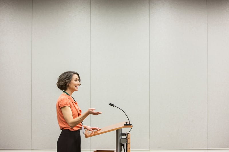 businesswoman-speaking-from-a-podium-to-an-audience-in-a-conference-room-how-to-give-a-good-presentation